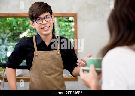 Café-restaurant, entrepreneur, jeune homme asiatique amical, qui s'en charge au comptoir Banque D'Images