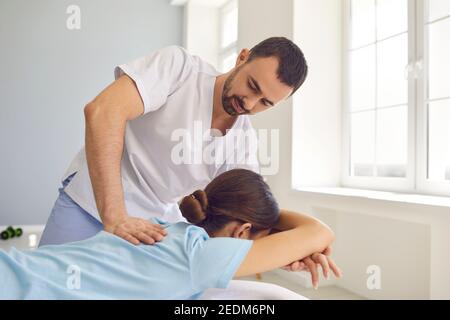 Ostéopathe en uniforme médical fixant les femmes aux épaules et au dos articulations en clinique de thérapie manuelle Banque D'Images