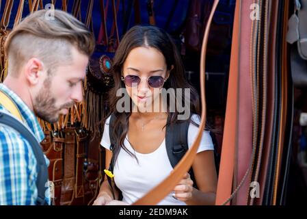 Couple de touristes à la recherche de produits en cuir dans la cabine de shopping à Marché extérieur à Bangkok Thaïlande en vacances Banque D'Images