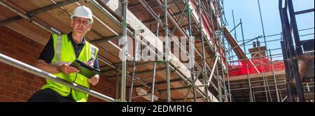 Homme de construction de Panorama contremaître, ouvrier de construction, entrepreneur ou architecte sur le chantier écrire sur le presse-papiers noir bannière panoramique de web Banque D'Images