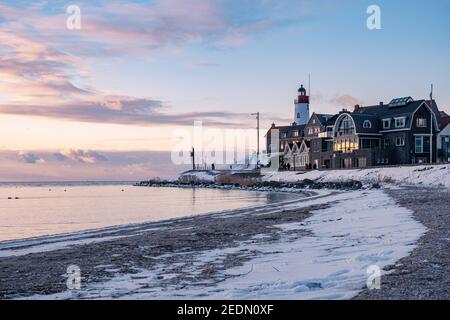 Hiver à Urk avec la digue et la plage au phare d'Urk neige couverte pendant l'hiver, coucher de soleil au phare d'Urk Flevoland. Pays-Bas Banque D'Images