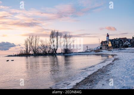 Hiver à Urk avec la digue et la plage au phare d'Urk neige couverte pendant l'hiver, coucher de soleil au phare d'Urk Flevoland. Pays-Bas Banque D'Images