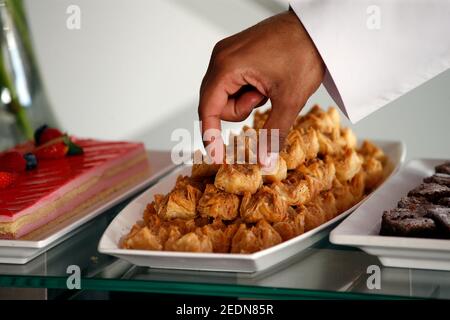 28.02.2020, Doha, , Qatar - main atteignant pour un morceau de baklava. 00S200228D185CAROEX.JPG [AUTORISATION DU MODÈLE : NON, AUTORISATION DU PROPRIÉTAIRE : NON (c) images de CARO / Banque D'Images