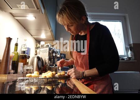 31.12.2020, Berlin, , Allemagne - femme décorant ses biscuits fraîchement cuits. 00S201231D583CAROEX.JPG [AUTORISATION DU MODÈLE : NON, AUTORISATION DU PROPRIÉTAIRE : NON (C) VOITURE Banque D'Images