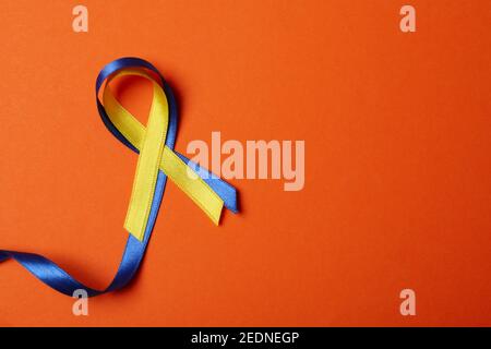 Rubans de sensibilisation au syndrome de Down sur fond orange Banque D'Images