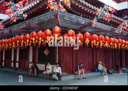 29.01.2021, Singapour, , Singapour - les personnes portant des masques de visage s'assoient devant le temple relique de la dent de Bouddha dans le quartier chinois, qui est décoré de rouge Banque D'Images