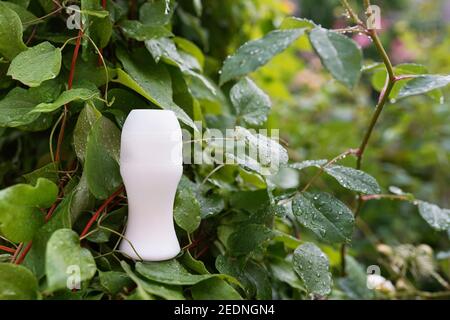 déodorant blanc avec gabarit et feuilles vertes fond nature, produits organiques de soins du corps Banque D'Images