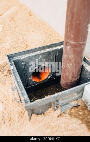 Système de drainage installation professionnelle - drainage de l'eau de pluie du toit dans un tuyau enterré dans le sol - eaux usées collecteur Banque D'Images