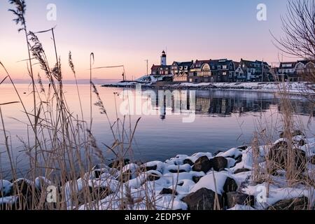 Hiver à Urk avec la digue et la plage au phare d'Urk neige couverte pendant l'hiver, coucher de soleil au phare d'Urk Flevoland. Pays-Bas Banque D'Images
