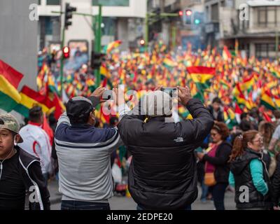 Deux hommes prennent des photos de foules de manifestants à la suite de la démission du président Evo Morales à la Paz, Bolivie, le 10 novembre 2019. Banque D'Images