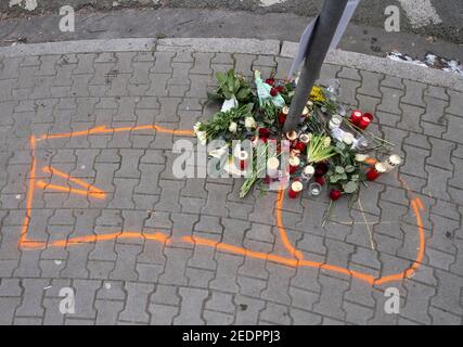 15 février 2021, Hessen, Francfort-sur-le-main: La police a utilisé la craie orange pour marquer le contour du corps de l'une des deux victimes d'un accident de la route mortel samedi dernier. Des fleurs et des bougies commémorent l'événement. Selon les enquêtes de la police jusqu'à présent, deux piétons ont été touchés par une voiture dont le conducteur conduisait à une vitesse manifestement excessive. Photo : Boris Roessler/dpa Banque D'Images