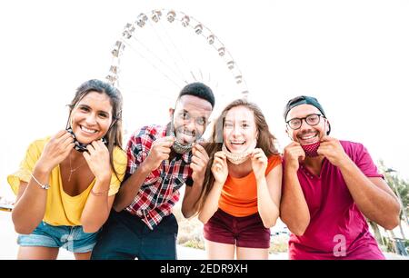 Des personnes multiculturelles prenant des photos heureuses avec des masques ouverts après La réouverture de verrouillage - Nouveau concept de style de vie normal avec de jeunes amis amuse-toi bien Banque D'Images