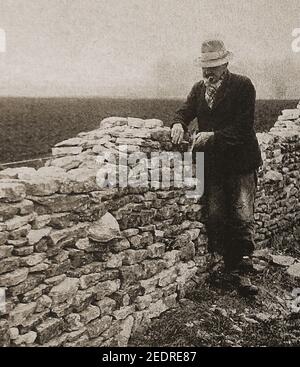 Une photo imprimée d'un artisan de Cotswold (Royaume-Uni) construit un mur en pierre sèche. Banque D'Images