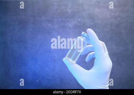main dans des gants en latex contenant le vaccin contre le coronavirus, avec espace pour les copies Banque D'Images
