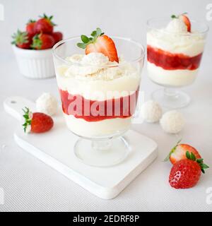 Dessert à la noix de coco avec mousse à la fraise. Crème moelleuse aux boules Raffaello, chocolat blanc et fraises fraîches. Banque D'Images