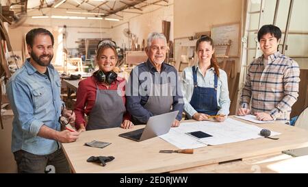 Groupe d'artisans comme une équipe de menuiserie avec des maîtres et des apprentis dans l'atelier Banque D'Images