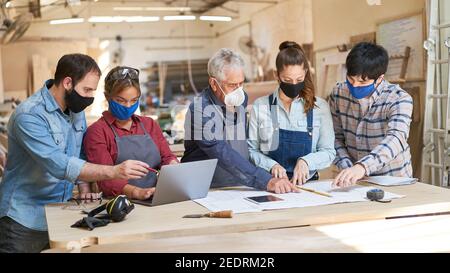 Les artisans font équipe avec les apprentis dans la discussion et la planification de nouveaux commandes Banque D'Images