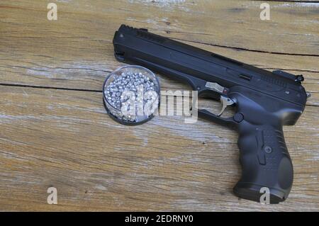 Pistolet à pression pour placer des pellets métalliques ou des boules métalliques, avec pistolet et boîte de pellets métalliques pour le tir sportif, pistolet noir sur fond de bois vieilli, Braz Banque D'Images