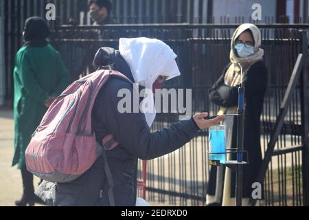 Srinagar, 15 février 2021. Une étudiante se lave les mains. Les collèges ont été fermés en raison du coronavirus. Après 12 mois, les collèges ont rouvert. Banque D'Images