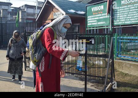 Srinagar, 15 février 2021. Un étudiant assainit ses mains. Les collèges ont été fermés en raison du coronavirus. Après 12 mois, les collèges ont rouvert. Banque D'Images