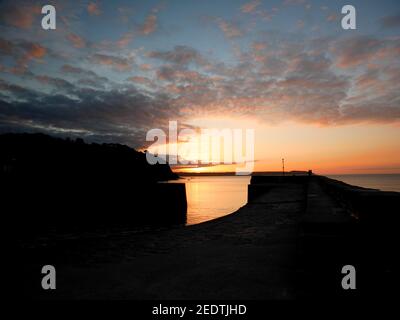 Lever du soleil sur la baie St Austell, vue depuis Charlestown, Cornwall. Banque D'Images