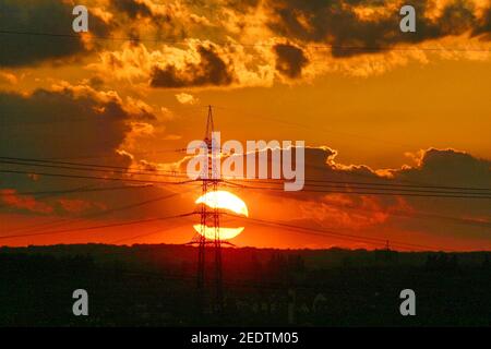 coucher de soleil derrière un pylône haute tension énergie solaire Banque D'Images