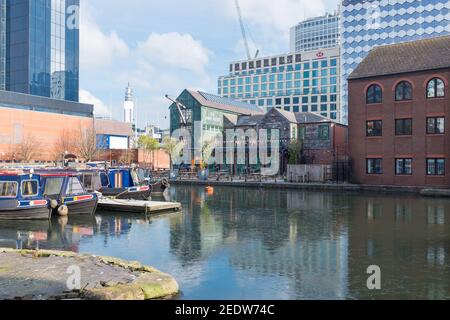 Des bateaux étroits amarrés dans Gas Street Basin, dans le centre-ville de Birmingham avec de grands bâtiments en arrière-plan Banque D'Images