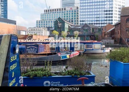 Des bateaux étroits amarrés dans Gas Street Basin, dans le centre-ville de Birmingham avec de grands bâtiments en arrière-plan Banque D'Images