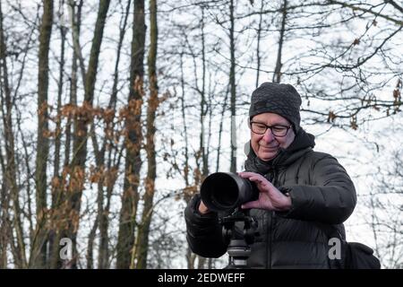 Un homme d'âge moyen avec un appareil photo sur un trépied dans une forêt. Photo de Lund, sud de la Suède Banque D'Images