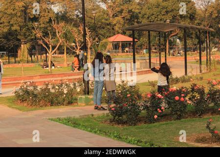 Enfants et autres personnes profitant du soleil d'hiver dans le jardin des roses de l'amitié des BRICS à Chanakyapuri, New Delhi, Inde pendant les vacances de dimanche Banque D'Images