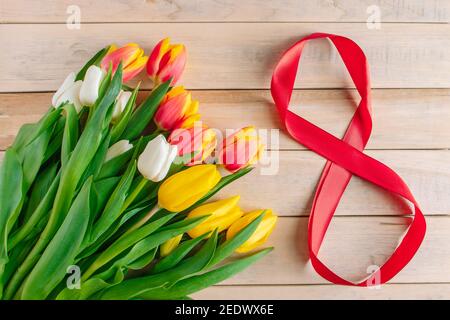 Bouquet de tulipes colorées sur fond de bois. Concept de la Journée internationale de la femme le 8 mars. Cadeau de Noël. Banque D'Images