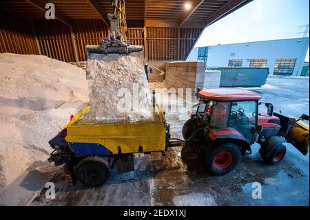 Une pelle hydraulique au travail dans un stockage de sel utilisé pour la lutte contre le dérapage sur route. Banque D'Images