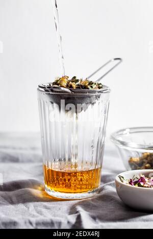 Verre de tisane avec camomille, rose et menthe. Concept de remède à la maison Banque D'Images