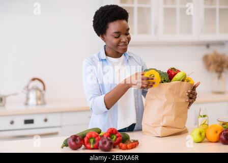 African Housewife Déballage après l'épicerie Shopping cuisine dans la cuisine moderne Banque D'Images