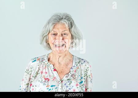 Femme âgée dans ses années 80 avec des cheveux gris isolés sur un fond blanc souriant et riant et heureux. Banque D'Images