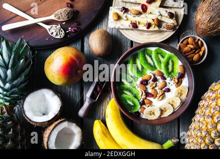 Yaourt avec différents fruits sur fond de bois. Nourriture utile, alimentation, biologique. Banque D'Images