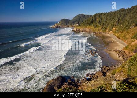 Côte près du phare de Heceta Head visible à distance sur la falaise près de Florence, Oregon, Etats-Unis Banque D'Images