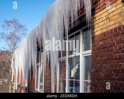 de grandes glaces pendent du toit Banque D'Images