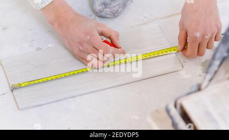 mesurer la réparation des carreaux dans la maison. Mise au point sélective. Blanc. Banque D'Images