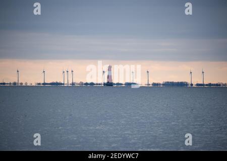 Wilhelmshaven, Allemagne. 10 février 2021. Nuages gris au-dessus des éoliennes et un phare à la baie de Jade. Credit: Jonas Walzberg/dpa/Alay Live News Banque D'Images