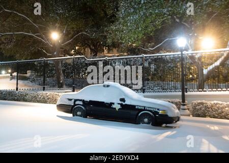 Austin, Texas États-Unis 15 février 2021 : une voiture de trooper de l'État du Texas se trouve devant le manoir du gouverneur, une rare chute de neige d'hiver mesurant au moins un demi-pied atteint le centre du Texas. Austin, Texas États-Unis 15 février 2021 : le parc du capitole du Texas, y compris la passerelle sud, est couvert de 6-7 pouces de neige rare lundi matin après une tempête d'hiver de nuit qui a explosé dans le centre du Texas. Les conditions météorologiques glaciales qui l'accompagnent ont fait des ravages sur le réseau électrique de l'État, causant des coupures de courant massives à des millions de clients à travers l'État. Credit: Bob Daemmrich/Alay Live News comme le Capitole de l'Etat et le Congrès Banque D'Images