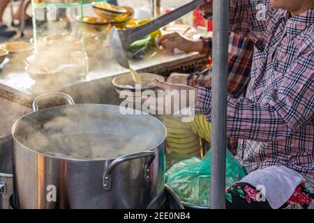 Femme vendant le porridge d'organes de porc de style vietnamien à la nourriture de rue fournisseur Banque D'Images