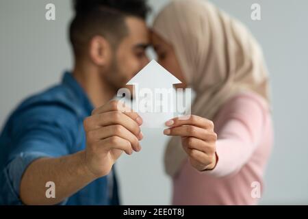 Jeune couple musulman aimant tenant une maison de papier Banque D'Images