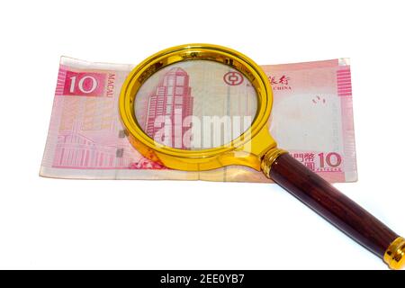 10 Macau argent patacas de papier sous une loupe isolée sur fond blanc, face avant Banque D'Images