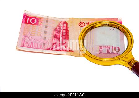 10 Macau patacas papier d'argent sous une loupe isolée sur fond blanc, face avant Banque D'Images