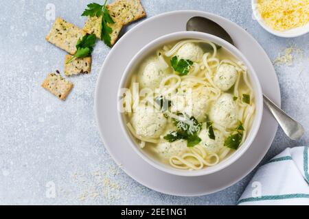 Soupe avec boulettes de poulet et pâtes aux œufs, parmesan et persil. Plats italiens pour enfants avec pâtes et viande. Cuisine italienne traditionnelle. Banque D'Images