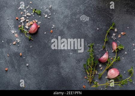 Cuisine de fond. Épices herbes et ail à table en ardoise noire. Vue de dessus des ingrédients alimentaires. Banque D'Images