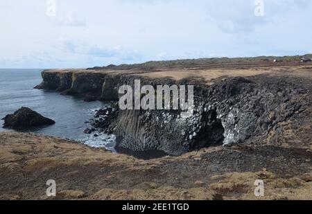 Superbes falaises de roche de lave et colonnes de basalte sur la côte. Banque D'Images