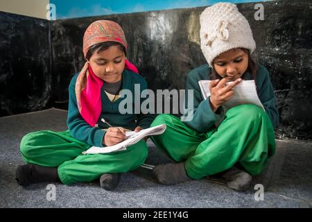 Uttar Pradesh. 05-15-2018. Les petites filles font leurs devoirs avant de vivre à l'école dans leurs maisons. Banque D'Images