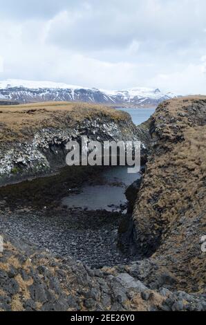 Jolie petite plage de roche de lave noire sur la côte de l'Islande. Banque D'Images